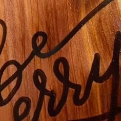 a wooden sign with the word derby written in cursive black ink on it