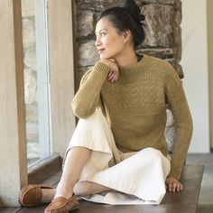 a woman is sitting on a wooden table