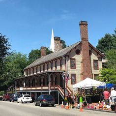 an old fashioned building on the corner of a street with cars parked in front of it