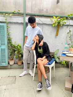 two people sitting on chairs in a greenhouse