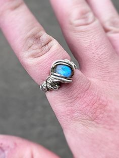 This ring was wire wrapped with silver wire, and a blue labradorite stone. The band has a detailed weive that will not leave a green mark on the skin. Unique Blue Wire Wrapped Rings, Adjustable Labradorite Crystal Ring, Blue Labradorite Moonstone Ring, Unique Blue Labradorite Ring, Bohemian Blue Labradorite Rings, Tiger Eye Bracelet, Sterling Silver Wire Wrap, Diy Wire Jewelry, Wire Wrapped Rings