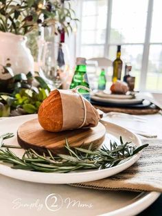 a white plate topped with bread on top of a wooden cutting board next to a potted plant