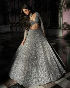 a woman in a silver gown standing on a checkered floor with her hands behind her back