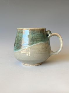 a green and white cup sitting on top of a table