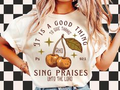 a woman wearing a t - shirt that says it's a good thing to live through and sing praise unto the lord