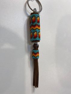 a keychain with a beaded design hanging from it's back end