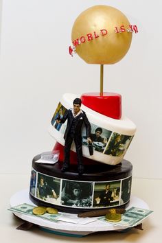 there is a cake with pictures on it and a gold ball atop the top one