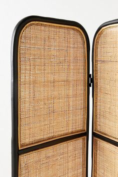 an open suitcase with wicker panels on the front and back sides, sitting against a white background