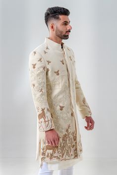 Ivory velvet sherwani featuring a blend of cut dana and zardozi embroidery, depicting scenic patterns. Comes with a kurta and pant.
Components: 3
Pattern: Embroidered
Type Of Work: Cut dana, Threadwork, Zardozi
Neckline: Mandarin Collar
Sleeve Type: Full
Fabric: Velvet
Color: Ivory
Other Details: 
Hidden fasteners
Embroidered floral, bird and foliage patterns
Straight silhouette
Occasion: Groom,Wedding - Aza Fashions Velvet Sherwani, Ivory Sherwani, Indian Wedding Clothes For Men, Sherwani For Men Wedding, Wedding Kurta For Men, Wedding Dresses Men Indian, Zardozi Embroidery, Kurta Men, Mens Kurta Designs