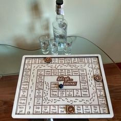 a wooden board game sitting on top of a table next to two glasses and a bottle