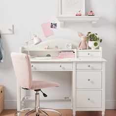 a white desk with two pictures on the wall