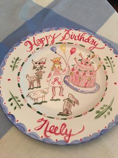 a birthday plate on a table with blue and white checkered table cloth, decorated with cartoon characters