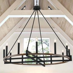 a chandelier hanging from the ceiling in a room with wooden beams and white walls