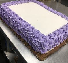 a square cake with purple frosting on a table