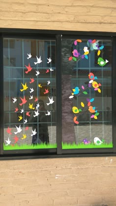 there is a window decorated with paper birds