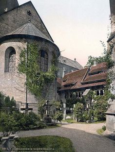 an old photo of a building with trees and bushes around it's courtyard area