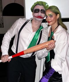 two people dressed up as the joker and person with green hair are posing for a photo