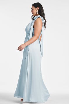 a woman in a light blue dress with a large bow on the back and shoulder