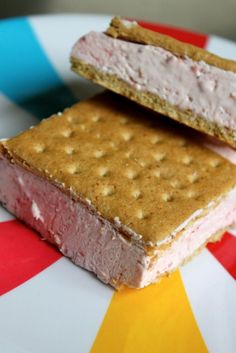 two ice cream sandwiches sitting on top of a white and red plate next to each other