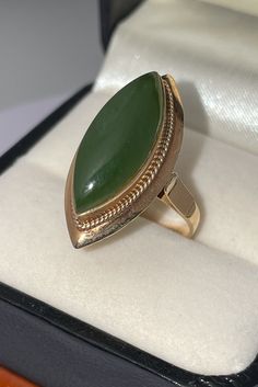 Beautifully vintage statement ring. Solid, stamped 14K Yellow Gold. Intricately detailed gallery work features a genuine Nephrite Jade gem. Ring size approximately 6.25. According to the Jade Hunt site, "Nephrite jade has been revered for thousands of years for its symbolism and cultural significance. It has been associated with various meanings, such as protection, prosperity, and good luck. Nephrite jade is believed to possess healing properties and spiritual meaning, often associated with the heart chakra. It is said to promote emotional balance, attract love, and encourage forgiveness." Good Fortune Jade Rings, Vintage Marquise Emerald Ring For Formal Occasions, Art Deco Jade Jewelry For Formal Occasions, Formal Art Deco Jade Jewelry, Antique Gold Emerald Cabochon Ring, Collectible Yellow Gold Emerald Cabochon Ring, Antique Yellow Gold Cabochon Emerald Ring, Antique Yellow Gold Emerald Cabochon Ring, Elegant Emerald Jade Ring With Cabochon