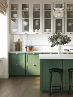 a kitchen with green cabinets and white counter tops