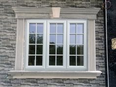 a white window sitting on the side of a brick building