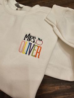 Personalized Teacher Embroidered Sweatshirt / Teacher name *The teacher's name will be in bright colors. If you would like it in one solid color, send me an email before you purchase.  Please review size chart before placing your order.  SHIPPING: Orders are shipped within 2 weeks. If you need the item sooner, message me.   CARE INSTRUCTIONS: Wash inside out and tumble dry on a low heat setting. Better results if you can wash on a cold cycle and hang/lay flat to dry. Hand Embroidered Teacher Shirt, Teacher Embroidered Shirt, Sweatshirt Teacher Outfit, White Letter Embroidery Sweatshirt For School, Cotton T-shirt With Embroidered Text For School, Cotton T-shirt With Embroidered Text, White Embroidered Sweatshirt For School, White Letter Embroidery Top For School, White Tops With Letter Embroidery For School