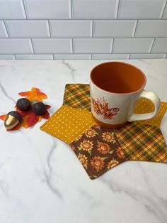 a cup of coffee sitting on top of a kitchen counter next to autumn leaves and acorns