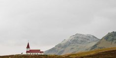 a church on a hill with mountains in the background