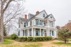 a large white house sitting on top of a lush green field