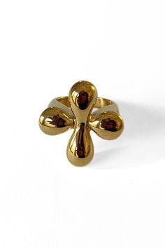 a gold ring with an unusual design on the front and center, set against a white background