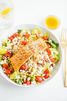 a white bowl filled with salad and salmon