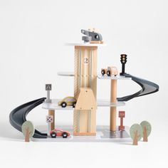 a wooden toy set with cars, trucks and trees on the top of it's shelves