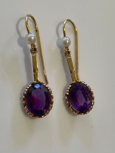 Vintage Edwardian style amethyst and pearl elegant earrings set in hallmarked 9ct yellow 9k gold. 2.2gm. 1.5inches long. Elegant Purple Gemstone Pearl Earrings, Elegant Purple Pearl Earrings For Anniversary, 14k Gold Oval Pearl Earrings, Victorian Hallmarked Pearl Earrings As Gift, Elegant Amethyst Earrings As A Gift, Formal Purple Pearl Drop Earrings, Elegant Purple Pearl Earrings For Formal Occasions, Elegant Purple Pearl Earrings, Yellow Gold Amethyst Earrings Hallmarked