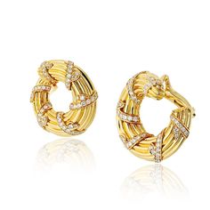 These stunning vintage Cartier hoop earrings are crafted in luxurious 18K yellow gold with a signature fluted design, making them a timeless piece for any jewelry collection. Measuring 1 inch wide, they are adorned with 3.40 carats of brilliant diamonds, boasting G-H color and VVS-VS clarity for exceptional sparkle. The clip-on style ensures comfort and ease of wear, while the impeccable craftsmanship reflects Cartier's dedication to elegance and sophistication. A true treasure, these earrings combine vintage allure with modern refinement, perfect for any special occasion or everyday luxury.Center Diamond Weight: 2.00Metal Type: 18K Yellow GoldMetal Weight: 40.7 gr.Signed: CartierCondition: Excellent.Stock: RR9799 Luxury Yellow Gold Hoop Earrings For Everyday Elegance, Designer Luxury Yellow Gold Hoop Earrings, Designer Cartier Yellow Gold Jewelry, Classic Luxury Cartier Earrings, Luxury Cartier Yellow Gold Earrings, Luxury Vintage Yellow Gold Pearl Earrings, Luxury Vintage Yellow Gold Clip-on Earrings, Luxury Yellow Gold Vintage Clip-on Earrings, Yellow Rings