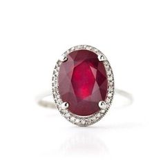 an oval shaped ruby and diamond ring on a white background with the center stone surrounded by diamonds