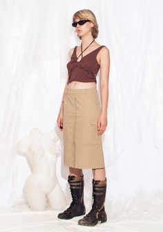 Y2K vintage cargo skirt. Made from cotton, this minimalist skirt comes in beige with four pockets to stash all your goodies. With a zip closure and 2000s vibes, it's the buttery-soft swag you need. Our model, Szonja is 173 cm / 67.5" tall and she's a size XS. Size: XS / US 2 / UK 6 / IT 38 Other size info: Labelled size: 34 Measurements:  waist: 72 cm / 28.1" length: 62 cm / 24.2" Fabric: cotton 97%, elastane 3% Care: Machine wash inside out Beige Cargo Skirt With Utility Style, Beige Utility Cargo Skirt, Khaki Cotton Cargo Skirt, Beige Cotton Cargo Skirt With Pockets, Fitted Khaki Cargo Skirt In Utility Style, Fitted Khaki Cargo Skirt With Utility Style, Fitted Khaki Utility Cargo Skirt, Cargo Skirt, Style Expert