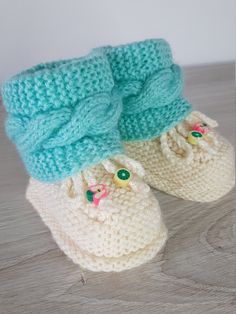 a pair of crocheted baby booties with bows on the front and bottom