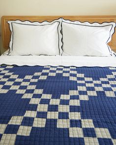 a blue and white quilt on top of a bed