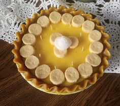 there is a pie with bananas in the middle on top of a lace doily