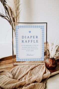 there is a sign that says diaper raffle next to some dried grass on a tray