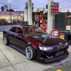 a purple car parked in front of a gas station