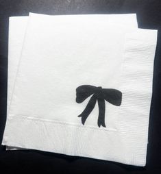 two white napkins with black bows on them