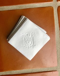 three folded napkins sitting on top of a brown tile floor