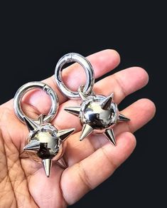 two silver metal stars and moon charms in someone's hand