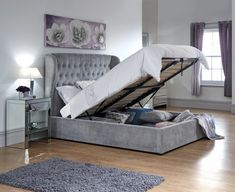 a bed with an open mattress on top of it in a room next to a window