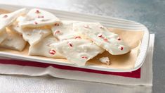 a white plate topped with candy canes on top of a red and white napkin