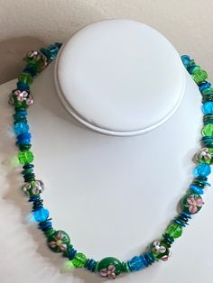 Green and Blue Crystal Beads Green and Blue Shells Flower Lampwork Beads Necklace is 17 inches and can come with 2.5 extender. Colorful Bead Flower Necklace For Beach, Colorful Beads Flower Necklace For Beach, Beach Necklace With Czech Glass Round Beads, Czech Glass Necklaces With Round Beads For Beach, Colorful Czech Glass Beaded Necklace For Beach, Czech Glass Beaded Necklaces For Beach, Turquoise Glass Beaded Necklaces For Jewelry Making, Blue Glass Beaded Necklaces, Blue Flower-shaped Beaded Necklaces With Colorful Beads