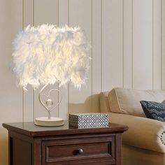 a table with a lamp on top of it next to a couch and chair in a room