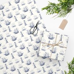 two wrapping paper wrapped in blue and white designs with scissors next to them on a table